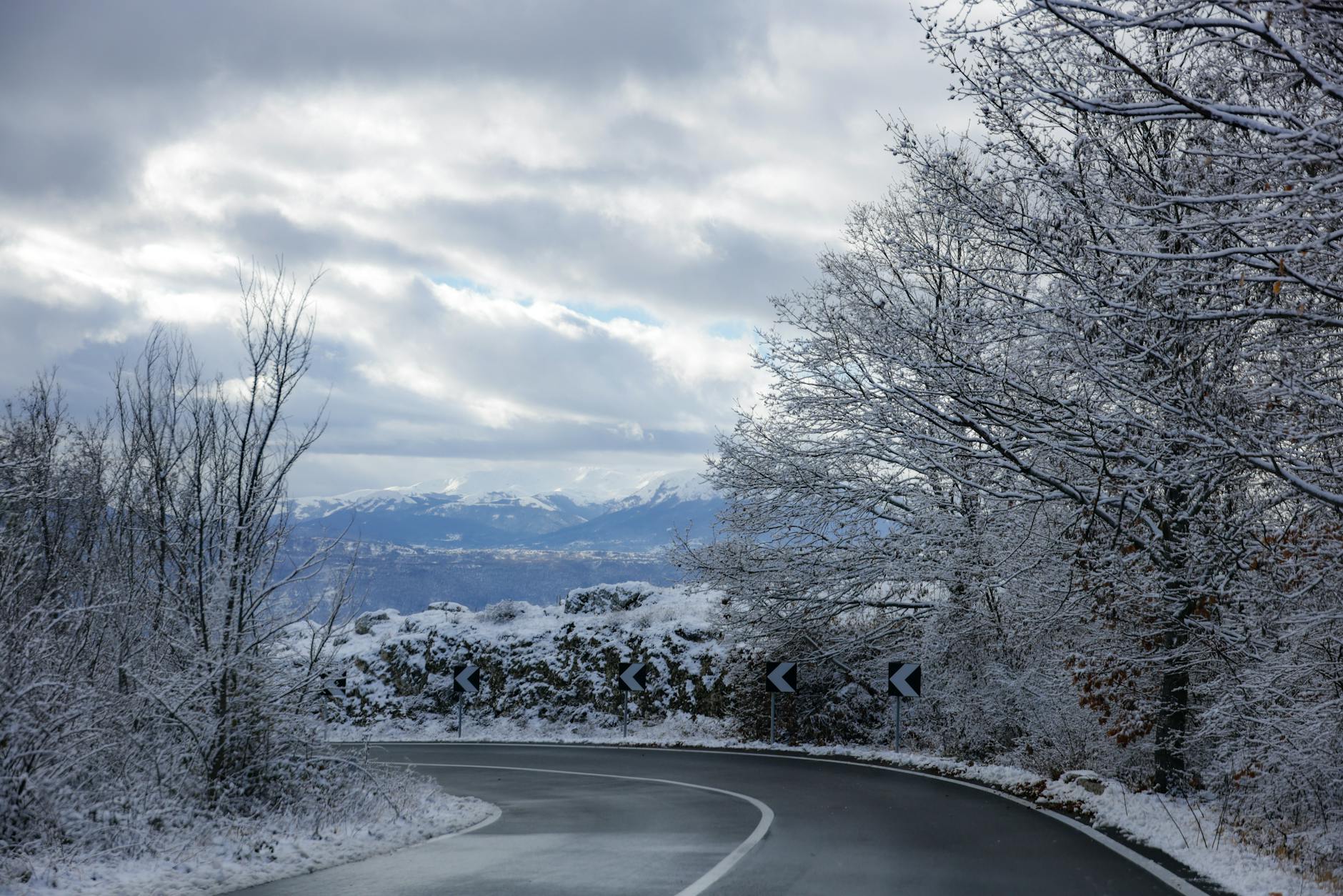 driving in greece winter - snow-covered mountain pass with trees